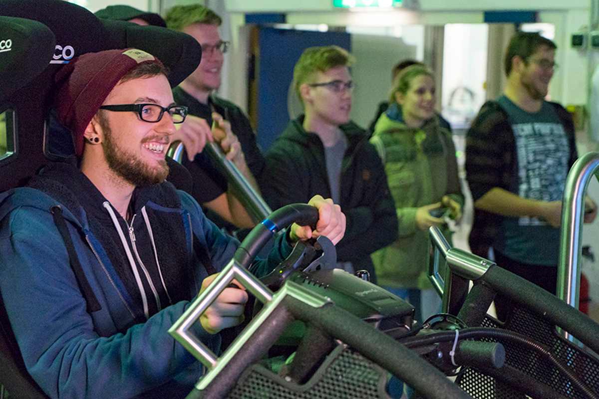 Eine Person sitzt in einem Fahrsimulator.